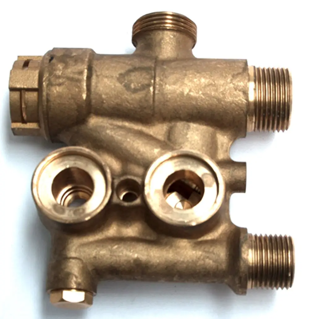 Bronzener Hydroblock mit mehreren Gewindeanschlüssen. Sichtbare Öffnungen für das 3-Wege Ventil. Produkt von Daikin für Heizungsanwendungen.
